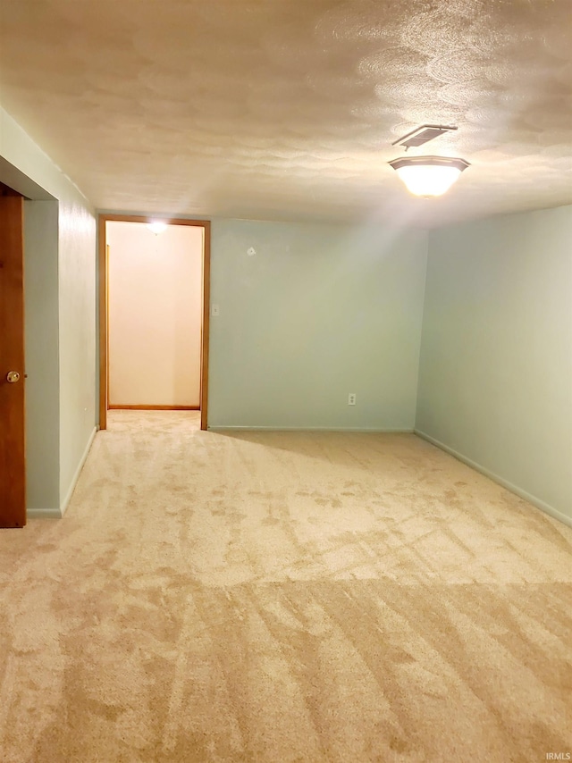 carpeted empty room featuring a textured ceiling