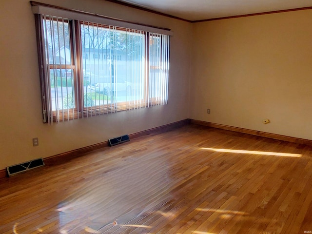 spare room featuring light hardwood / wood-style flooring and crown molding