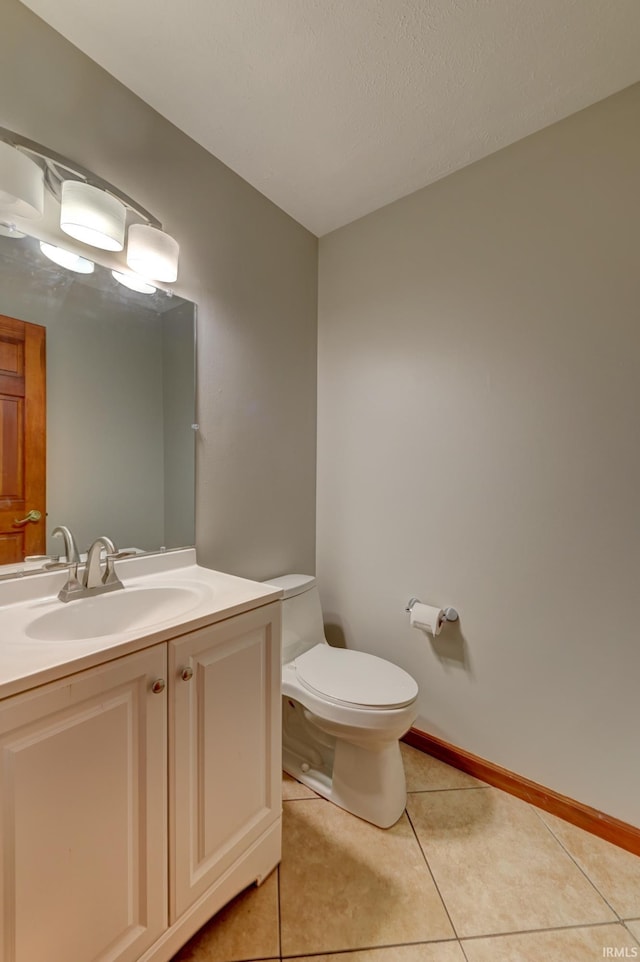 bathroom featuring tile patterned flooring, vanity, a textured ceiling, and toilet