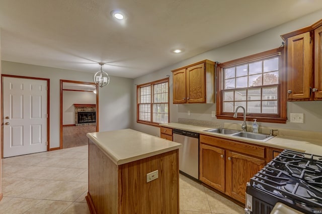 kitchen with light tile patterned flooring, sink, appliances with stainless steel finishes, a center island, and a brick fireplace