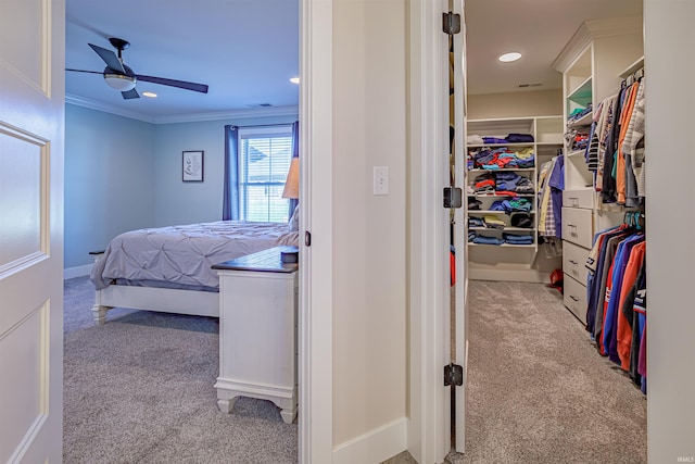 carpeted bedroom with ceiling fan, crown molding, and a closet