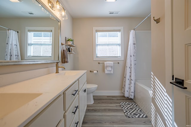 full bathroom with toilet, wood-type flooring, vanity, and shower / bathtub combination with curtain