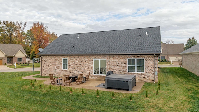 rear view of property featuring a hot tub, a patio area, and a lawn