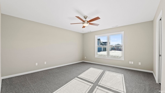 unfurnished room with ceiling fan and dark colored carpet