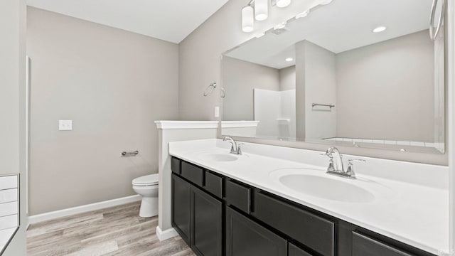 bathroom featuring toilet, a shower, vanity, and hardwood / wood-style floors