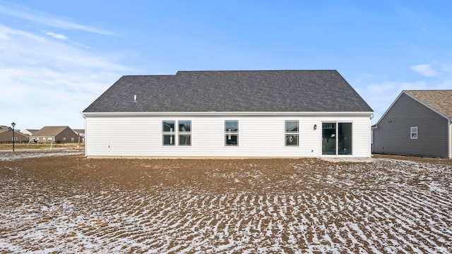 view of snow covered back of property