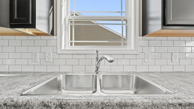 details featuring tasteful backsplash and sink