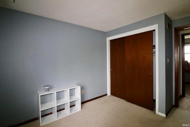 carpeted bedroom featuring a textured ceiling and a closet