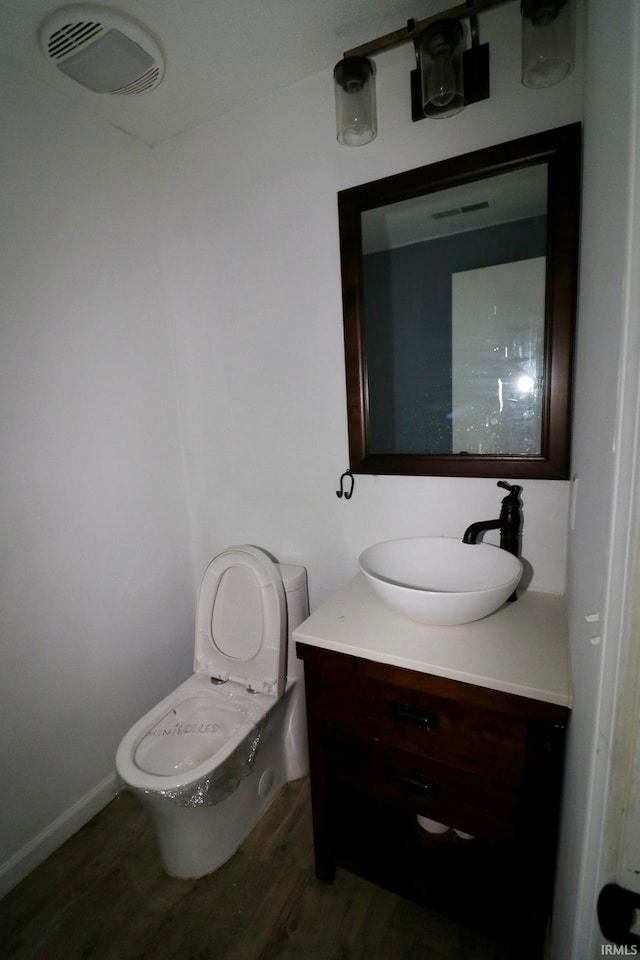 bathroom with wood-type flooring, toilet, and vanity