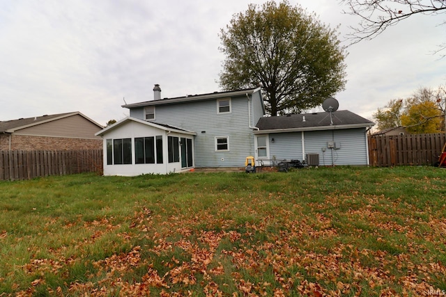 back of house featuring a sunroom, a yard, and cooling unit