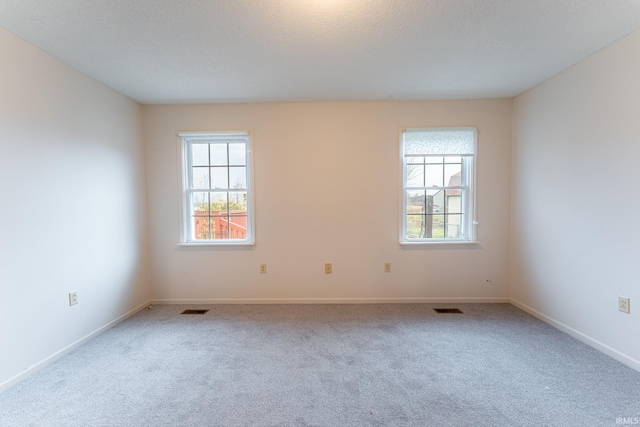 carpeted spare room featuring a textured ceiling