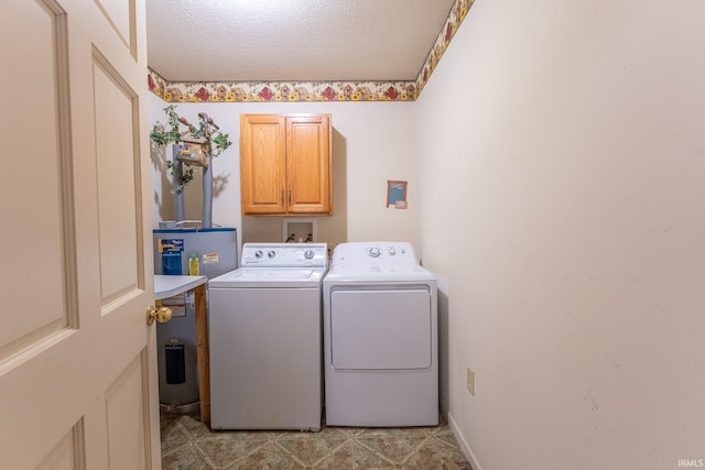 washroom featuring cabinets, washing machine and dryer, and a textured ceiling