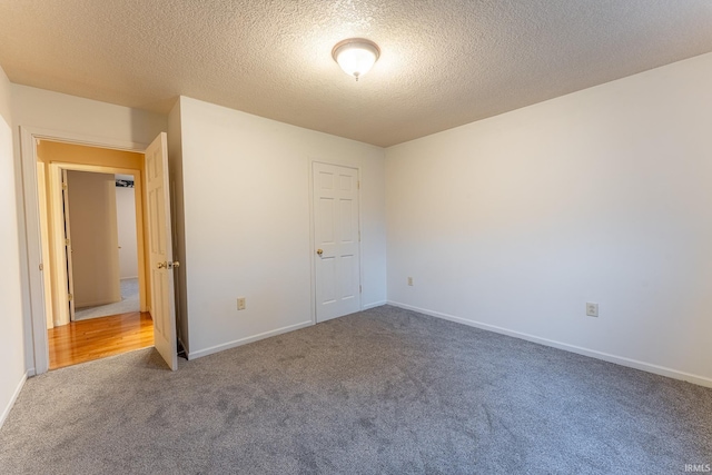 empty room with a textured ceiling and carpet floors