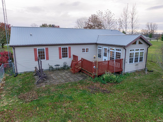 rear view of house with a deck, a lawn, and a patio