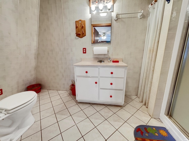 bathroom with toilet, tile walls, tile patterned flooring, vanity, and walk in shower