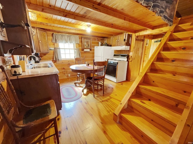 dining area with wood walls, light hardwood / wood-style floors, beamed ceiling, wooden ceiling, and sink