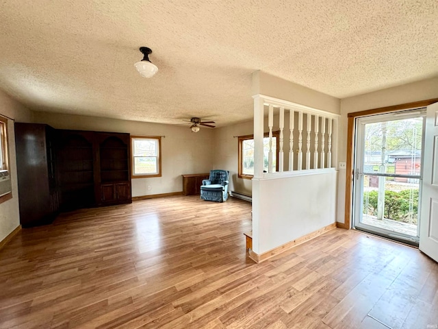 entrance foyer with light wood-type flooring, a baseboard radiator, a textured ceiling, and ceiling fan