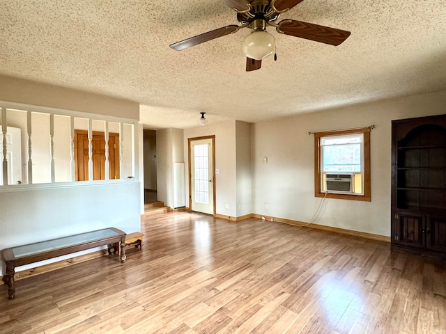 unfurnished room with cooling unit, a textured ceiling, ceiling fan, and light hardwood / wood-style flooring