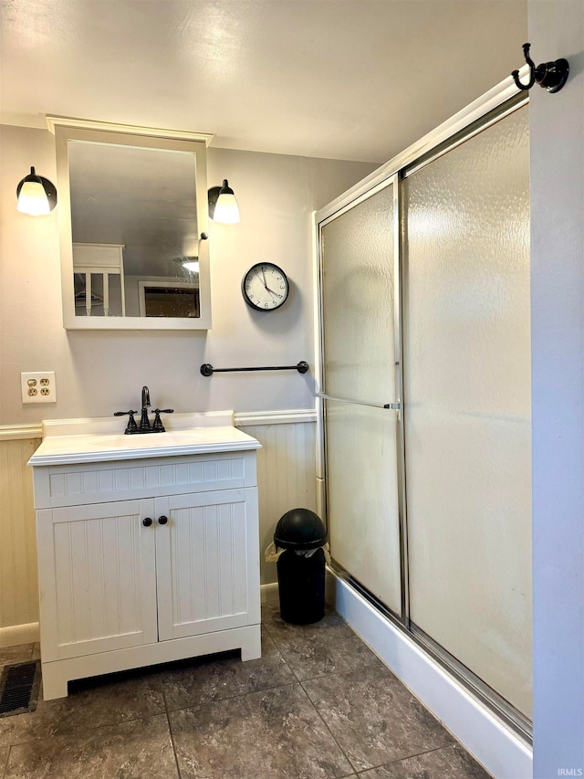 bathroom with walk in shower, vanity, and wooden walls