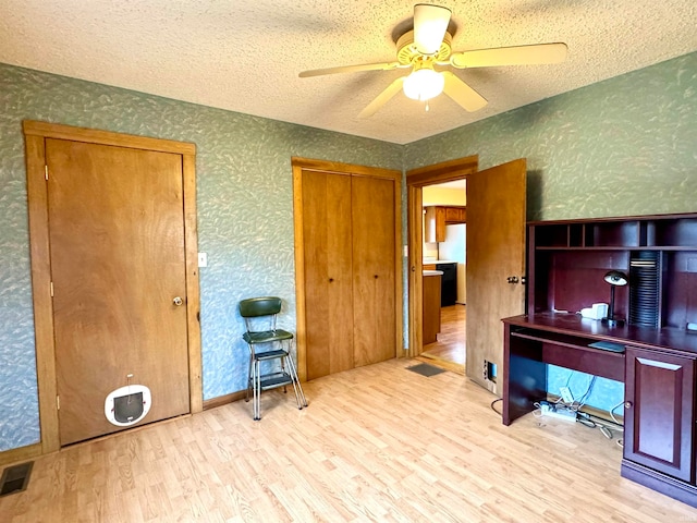 home office featuring light wood-type flooring, a textured ceiling, and ceiling fan