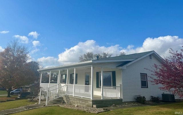 view of front facade featuring central air condition unit, a porch, and a front lawn