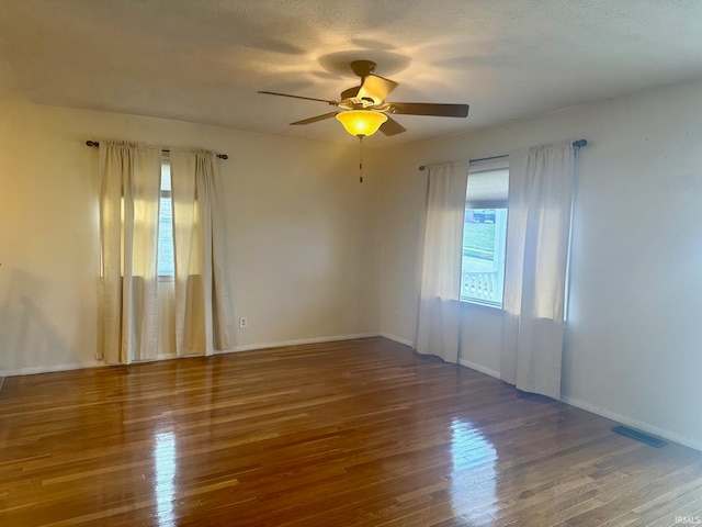 unfurnished room featuring a textured ceiling, hardwood / wood-style floors, and ceiling fan