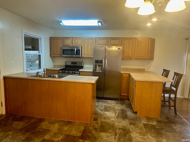 kitchen featuring stainless steel appliances, kitchen peninsula, a breakfast bar area, pendant lighting, and light brown cabinetry