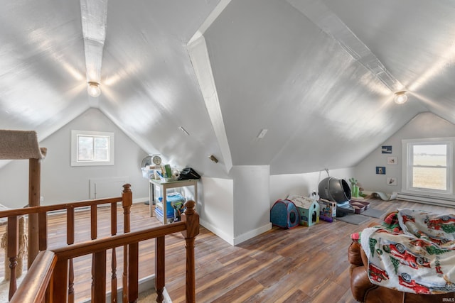 additional living space with hardwood / wood-style floors and vaulted ceiling