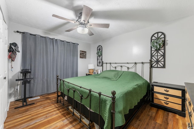 bedroom featuring hardwood / wood-style flooring, ceiling fan, and a textured ceiling