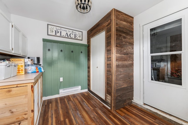 kitchen with white cabinets, a baseboard radiator, and dark wood-type flooring