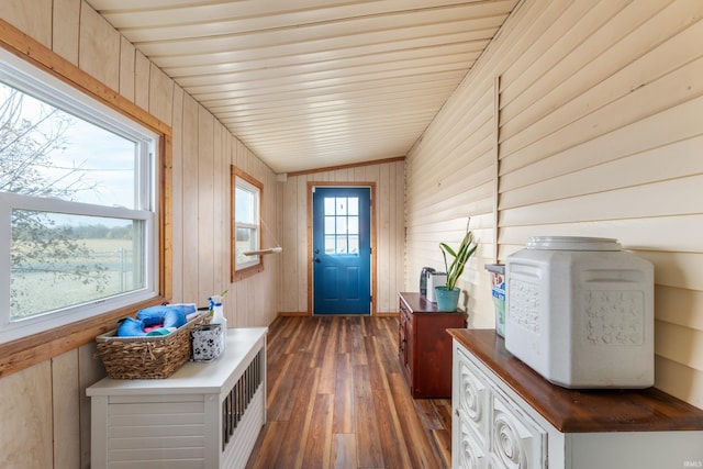 entryway featuring dark wood-type flooring, wooden walls, lofted ceiling, and wooden ceiling