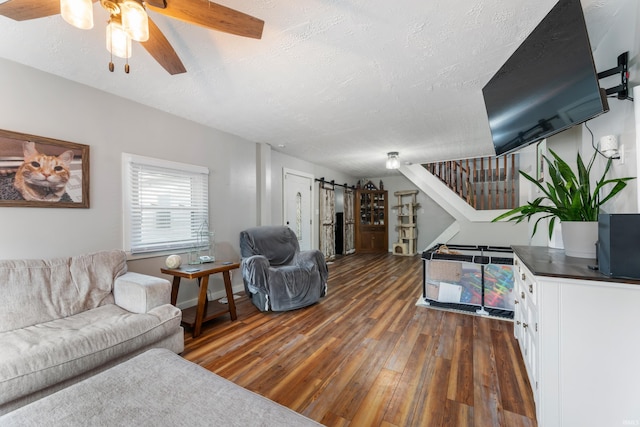 living room featuring a textured ceiling, dark hardwood / wood-style floors, and ceiling fan