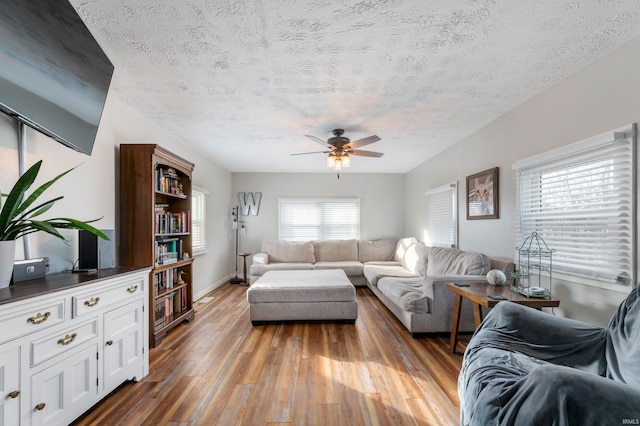 living room featuring a textured ceiling, hardwood / wood-style flooring, and ceiling fan