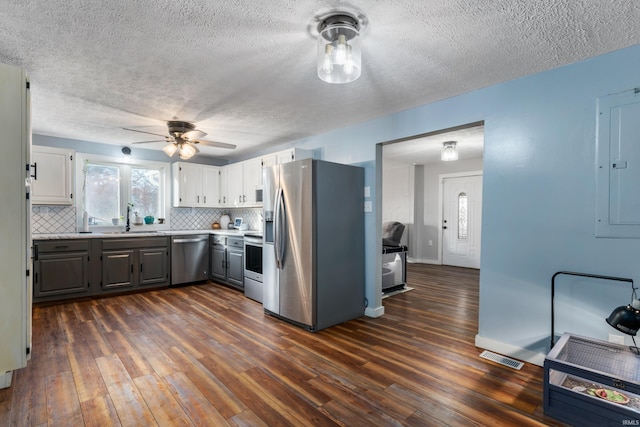 kitchen featuring sink, appliances with stainless steel finishes, dark hardwood / wood-style floors, backsplash, and gray cabinetry