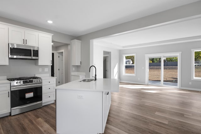 kitchen with a center island with sink, sink, white cabinetry, and appliances with stainless steel finishes