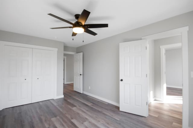 unfurnished bedroom featuring ceiling fan, dark hardwood / wood-style floors, and a closet