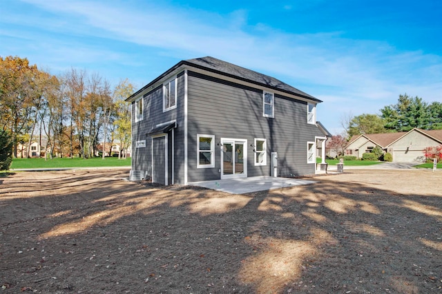 rear view of house with central AC unit and a patio