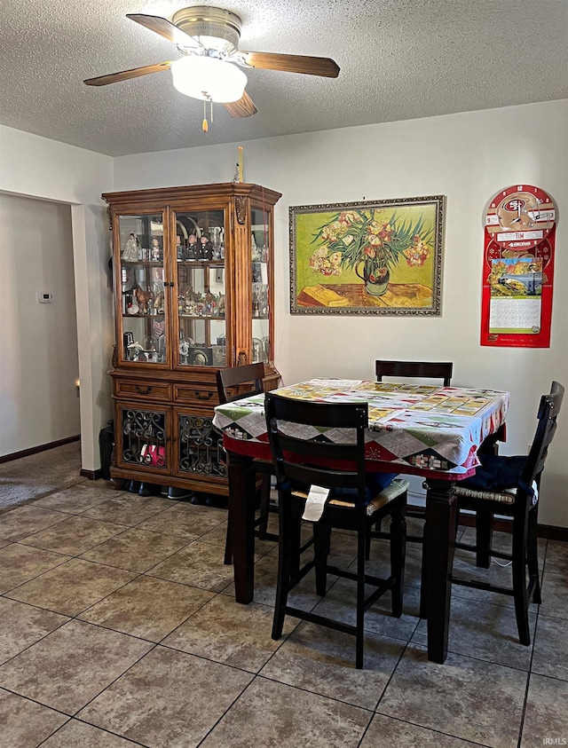 dining room featuring a textured ceiling, tile patterned flooring, and ceiling fan