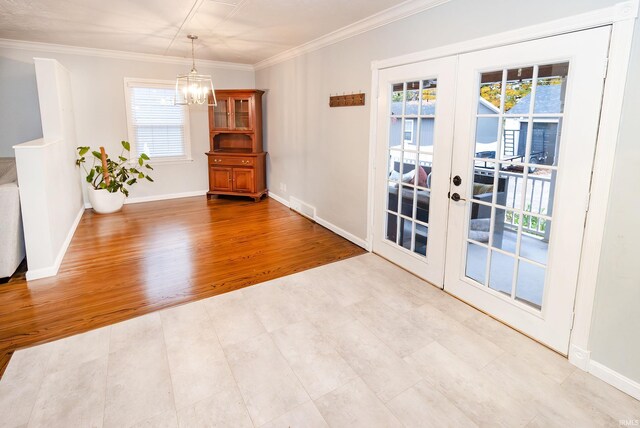 interior space featuring french doors, light hardwood / wood-style flooring, a chandelier, and crown molding