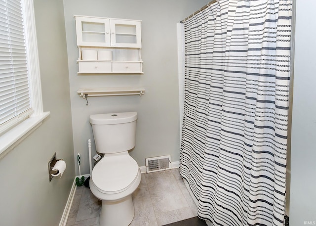 bathroom featuring toilet, a shower with shower curtain, and hardwood / wood-style flooring