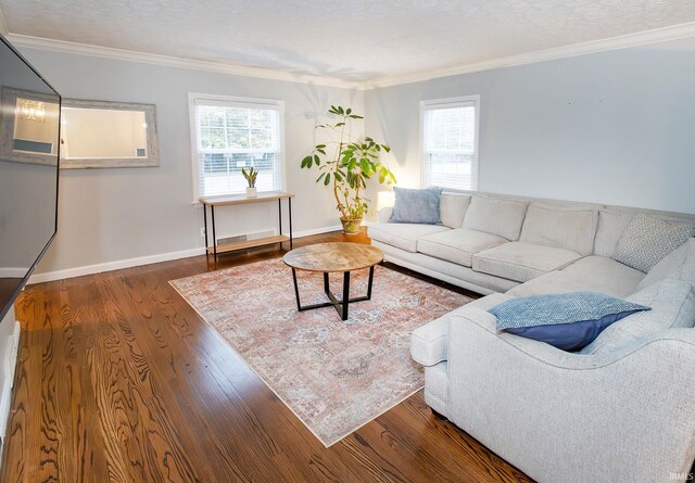 living room with a healthy amount of sunlight, dark hardwood / wood-style flooring, and crown molding