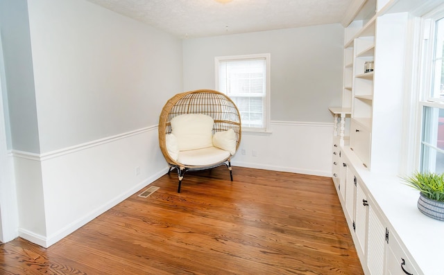 sitting room with a textured ceiling and light wood-type flooring