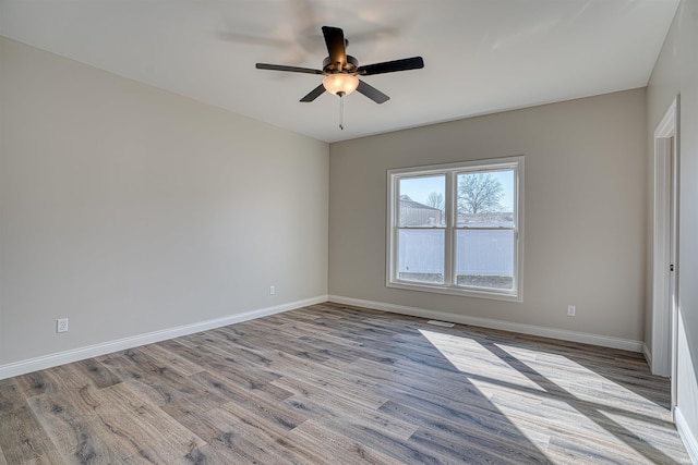 spare room with ceiling fan and light wood-type flooring