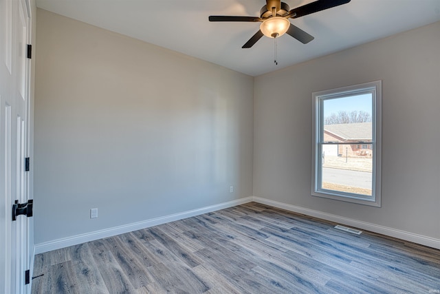 empty room with ceiling fan and light hardwood / wood-style floors