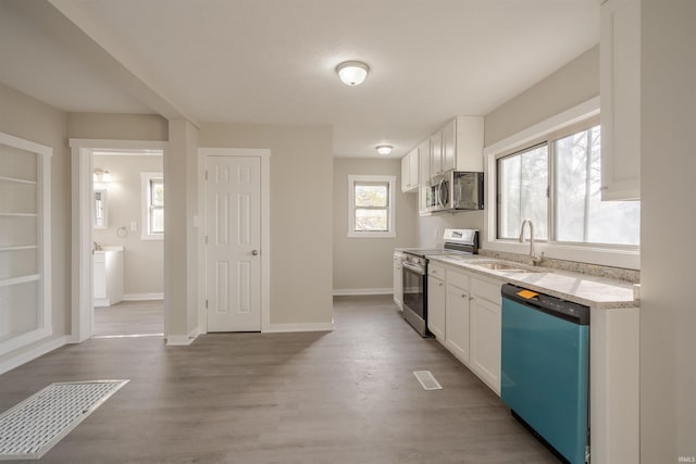 kitchen featuring hardwood / wood-style flooring, white cabinetry, and appliances with stainless steel finishes