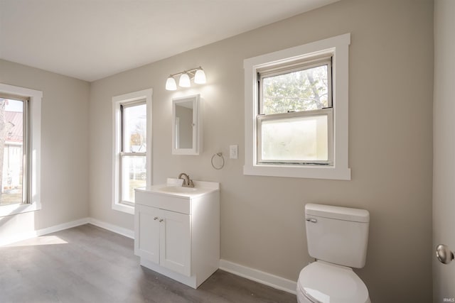 bathroom with hardwood / wood-style floors, a wealth of natural light, and toilet