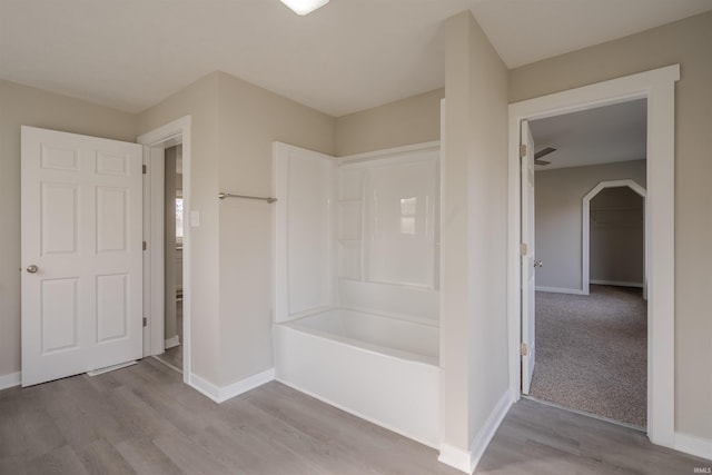 bathroom featuring wood-type flooring, ceiling fan, and tub / shower combination