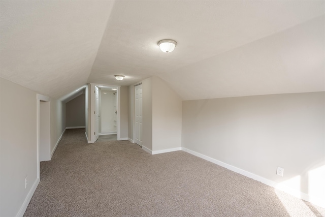 bonus room featuring lofted ceiling and light colored carpet