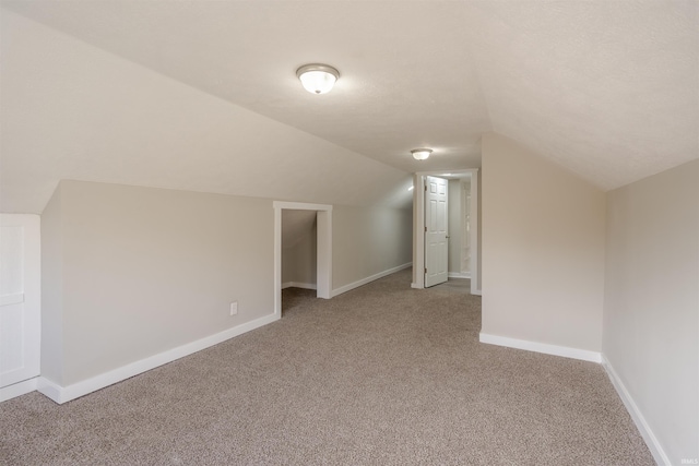 additional living space with carpet and vaulted ceiling