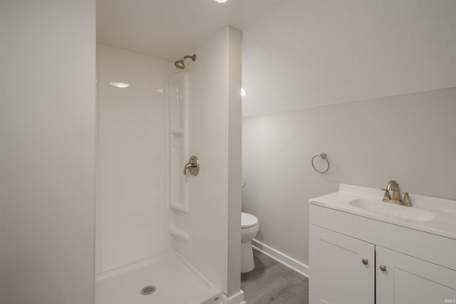 bathroom with walk in shower, wood-type flooring, toilet, and vanity